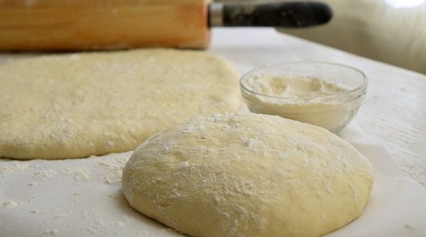 Pizza Dough on a table with a rolling pin