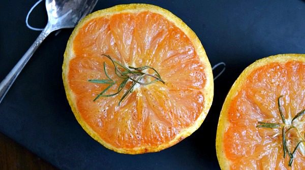 Honey Broiled Grapefruit on a black plate with a spoon