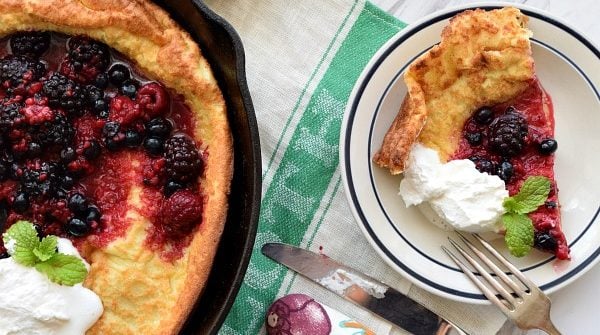 a slice of Dutch Baby with Berries and Whipped Cream
