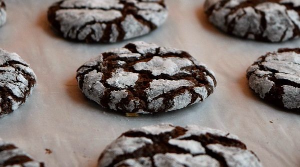 close up of a chocolate peppermint crinkle cookie on a baking sheet