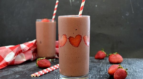 square image of 2 strawberry chocolate smoothies, strawberries stuck like hearts in the side of the smoothie