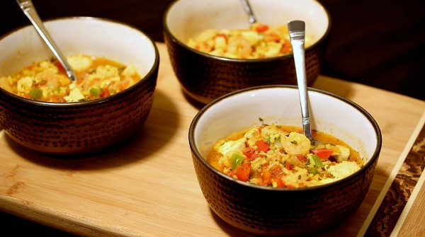 three bowls of chicken and shrimp paella on a table