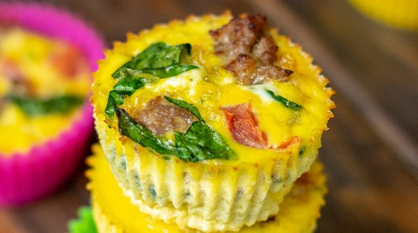 close up of a freshly made spinach, sausage, tomato egg muffin