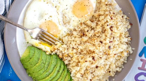 overhead shot of a plate full of breakfast eggs with cauliflower rice and avocado