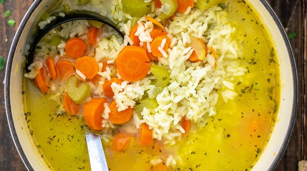 carrots, celery, and rice in a soup pot