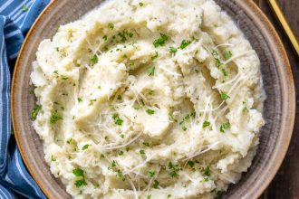 bowl of garlic parmesan mashed cauliflower on a wood table