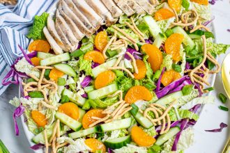 Asian Chopped Chicken Salad on a large plate on a tables with garnishes