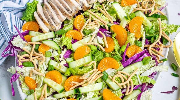 Asian Chopped Chicken Salad on a large plate on a tables with garnishes