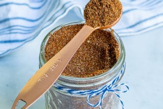 spoon full of taco seasoning simple resting on a jar full of taco seasoning