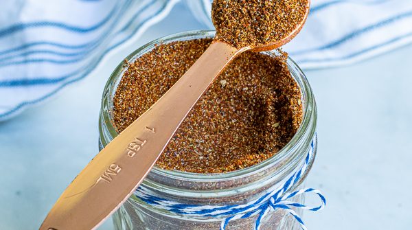 spoon full of taco seasoning simple resting on a jar full of taco seasoning