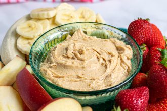 platter with peanut butter fruit dip surrounded by cut up fruit
