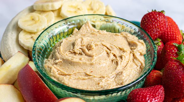 platter with peanut butter fruit dip surrounded by cut up fruit