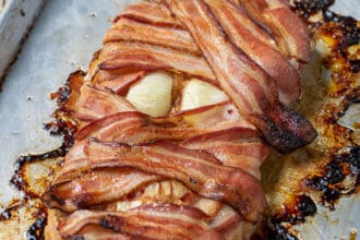 bacon wrapped meatloaf mummy on a sheet pan perfect for halloween dinner
