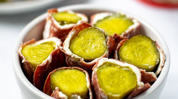 white bowl full of dried beef pickle roll ups