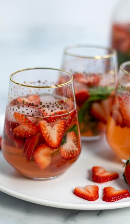 glasses of strawberry sangria with heart shaped strawberries and basil perfect for Valentine's Day, brunches, and bridal showers