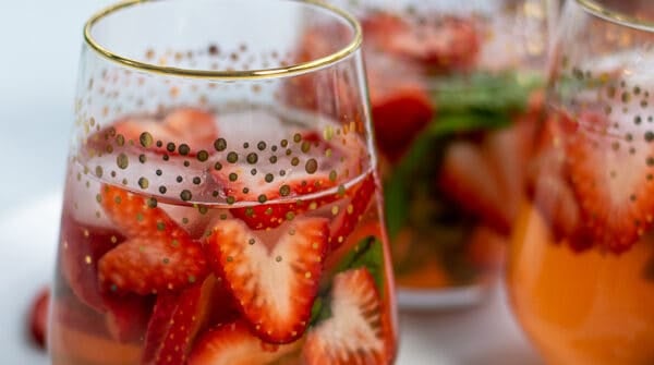 glasses of strawberry sangria with heart shaped strawberries and basil perfect for Valentine's Day, brunches, and bridal showers