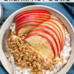 Pinterest Pin with text 'Apple Cinnamon Cottage Cheese Breakfast bowl', image of a bowl on a blue towel filled with cottage cheese, apple slices, and granola.