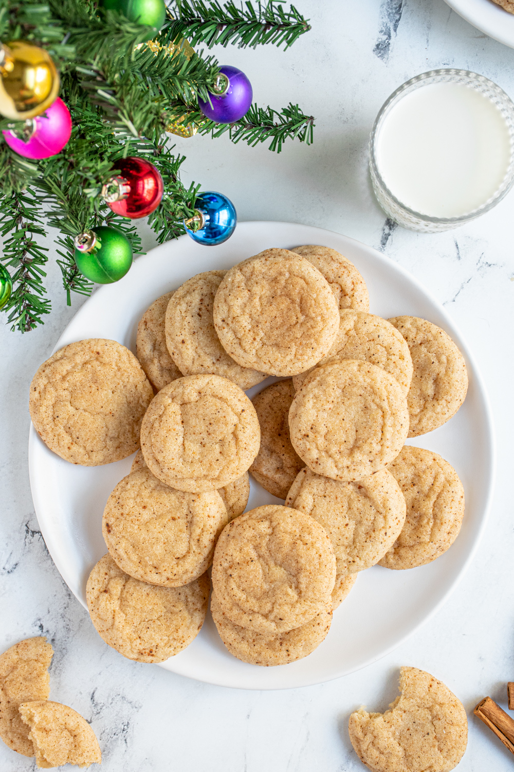 Overhead view of a plate full of eggnog snickerdoodles showing off a cinnamon and nutmeg outside.