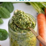 Pinterest pin with text overlay "Carrot Top Pesto", image of a glass jar with green carrot top pesto.