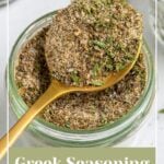 Pinterest Pin with text overlay "Greek Seasoning Recipe", image of a jar with a resting spoon full of greek seasoning.