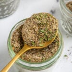 Pinterest Pin with text overlay "Greek Seasoning Recipe", image of a jar with a resting spoon full of greek seasoning.