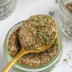 Pinterest Pin with text overlay "Greek Seasoning Recipe", image of a jar with a resting spoon full of greek seasoning.