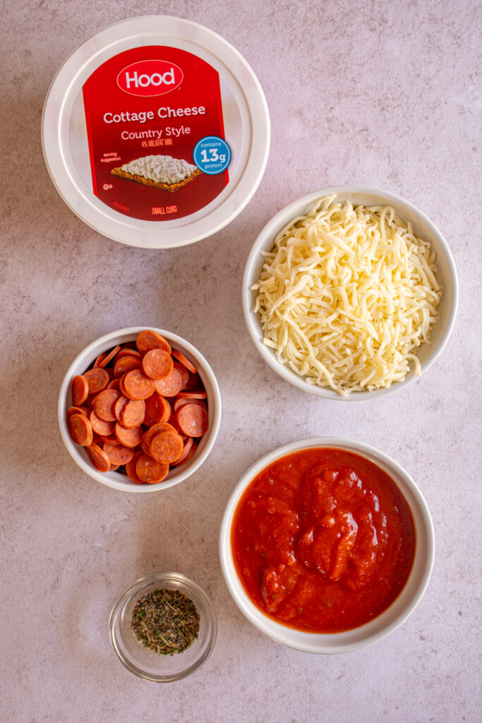 Ingredients to make cottage cheese pizza dip laid out on a tabletop.