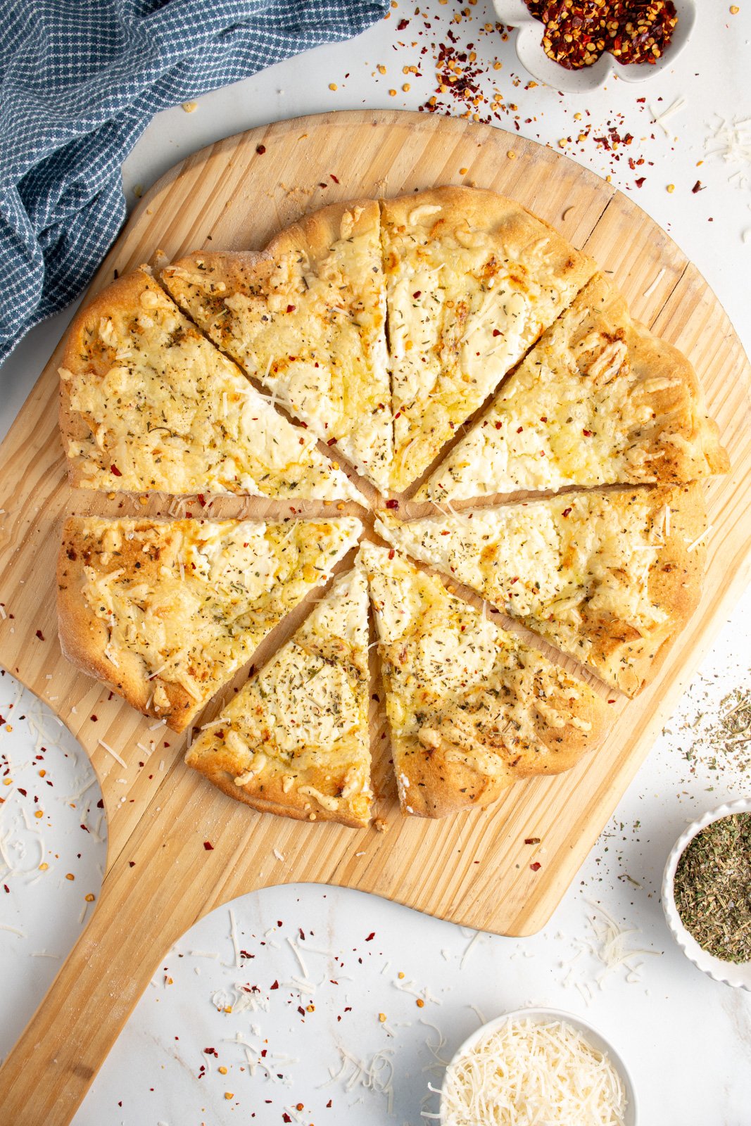 A sliced white pizza on a wood pizza peel.