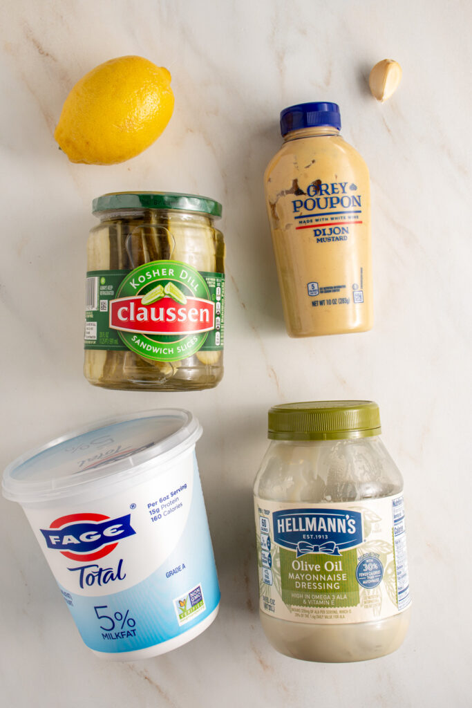 Ingredients laid out on a tabletop for making tartar sauce.
