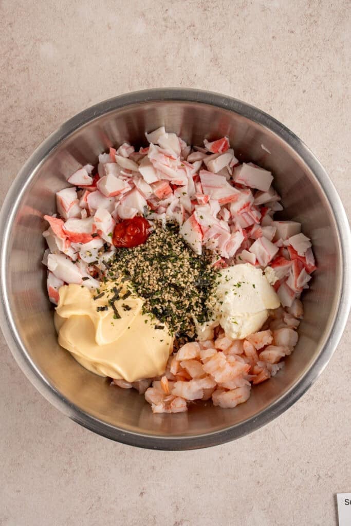 A bowl with all the crab mixture ingredients inside.