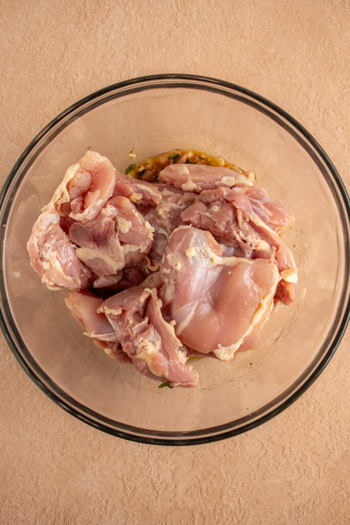 Raw chicken thighs in a bowl.