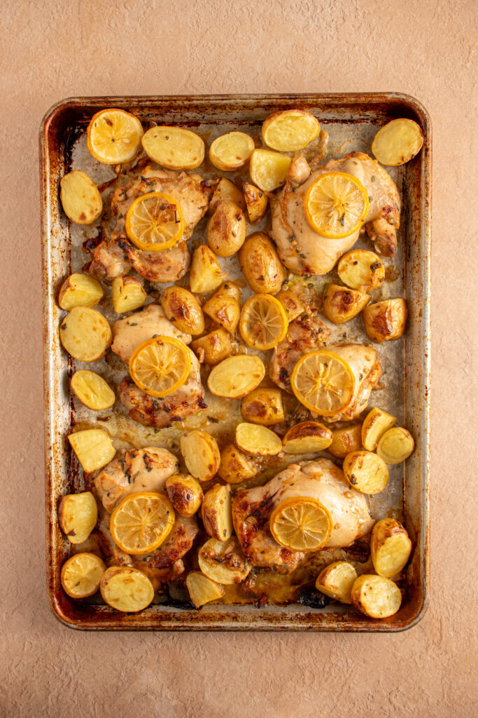 Fresh out of the oven a sheet pan with balsamic chicken thighs, lemon, and potatoes.