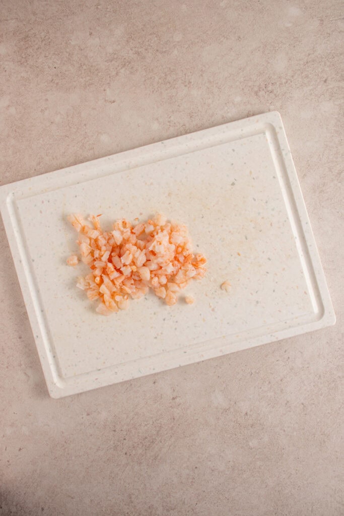 Chopped shrimp on a cutting board.