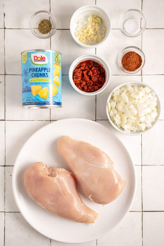 All the ingredients to make pineapple chicken tacos laid out on a tabletop.