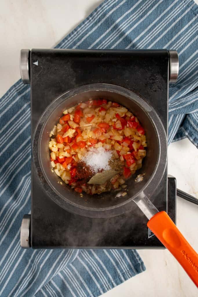 Spices and seasoning to the small pot for beans.