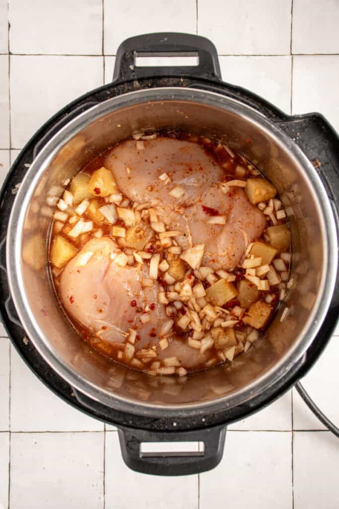 All the raw ingredients mixed in the pot of a pressure cooker.