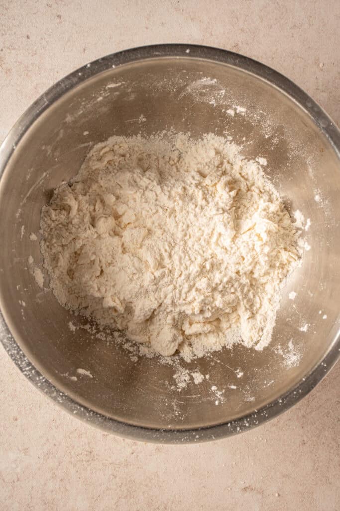 Butter mixed into the dry ingredients for making biscuits.