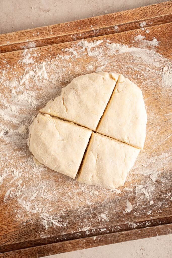 Biscuit dough cut into four biscuits.