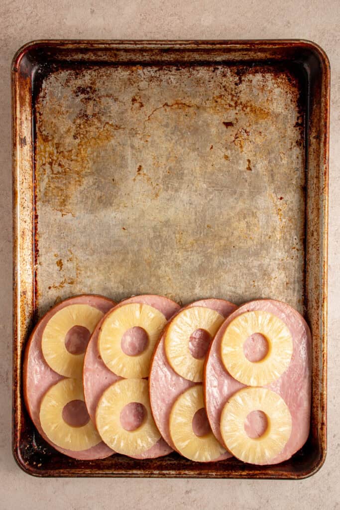 Ham and pineapple added to a sheet pan.