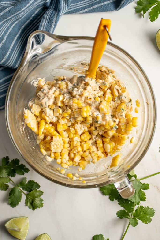 Stirring together the elote dip in a bowl.