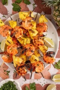 A plate with grilled pineapple shrimp skewers.