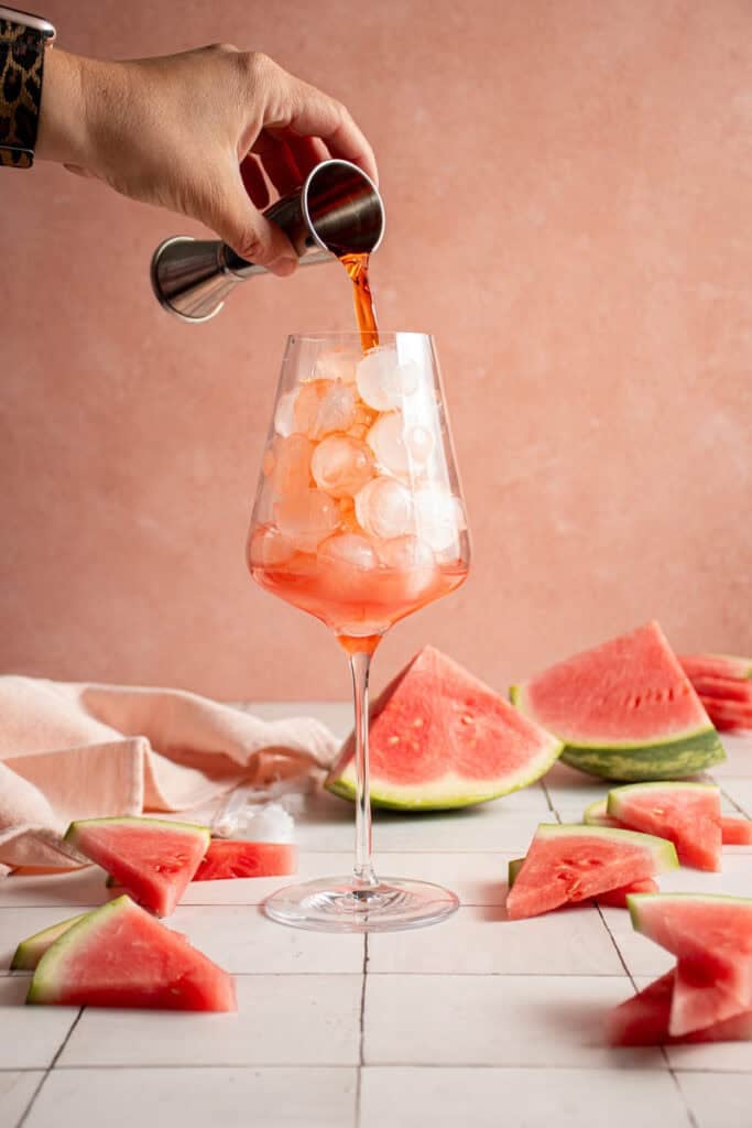 Pouring Aperol into a glass.