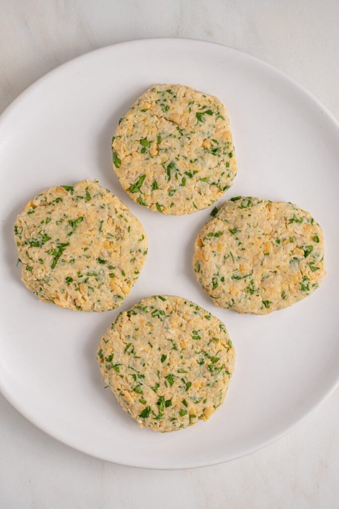 Raw chickpea fritters patties on a plate.