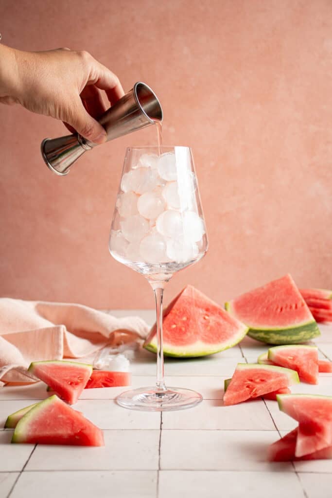 Pouring watermelon juice into a glass.