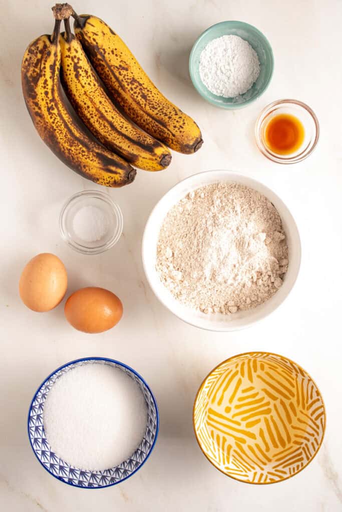 Ingredients laid out on a table top to make whole wheat banana muffins.