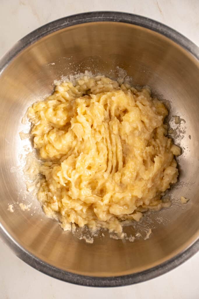 Mashed bananas in a bowl for making whole wheat banana muffins.
