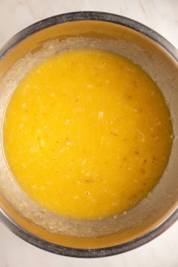 Mixed wet ingredients in a mixing bowl to make whole wheat banana muffins.