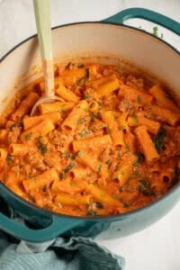 A dutch oven filled with Creamy One Pot Sausage Rigatoni.