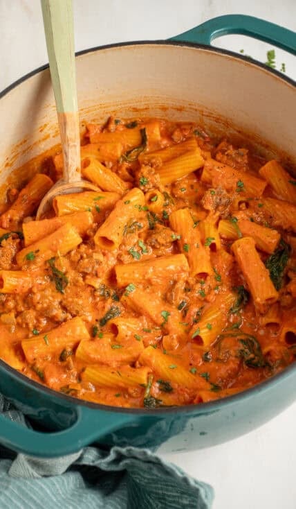 A dutch oven filled with Creamy One Pot Sausage Rigatoni.