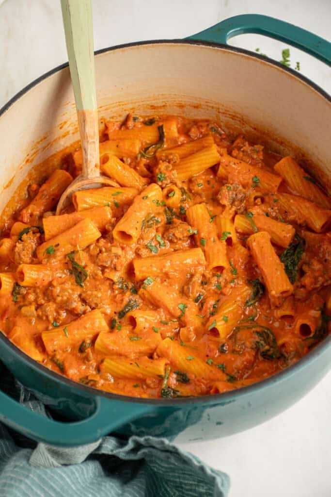 A dutch oven filled with Creamy One Pot Sausage Rigatoni.